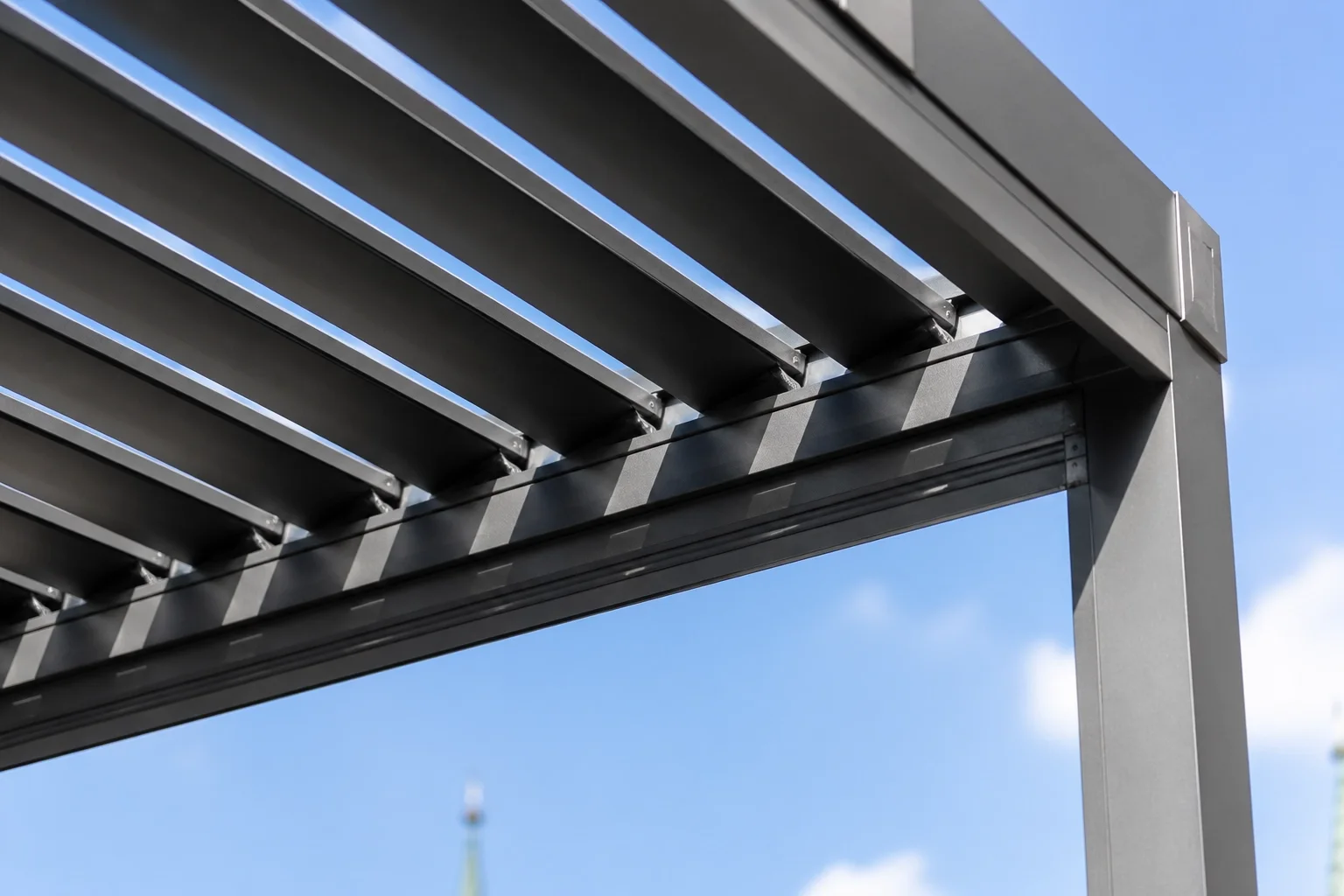 Bioklimatisches Lamellendach in Wien aus anthrazitfarbenem Aluminium mit verstellbaren Lamellen.