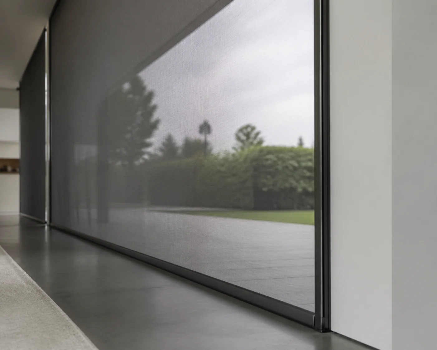 Transparenter Zip Screen Wien in Anthrazit vor einer Glasfront für optimalen Hitzeschutz.