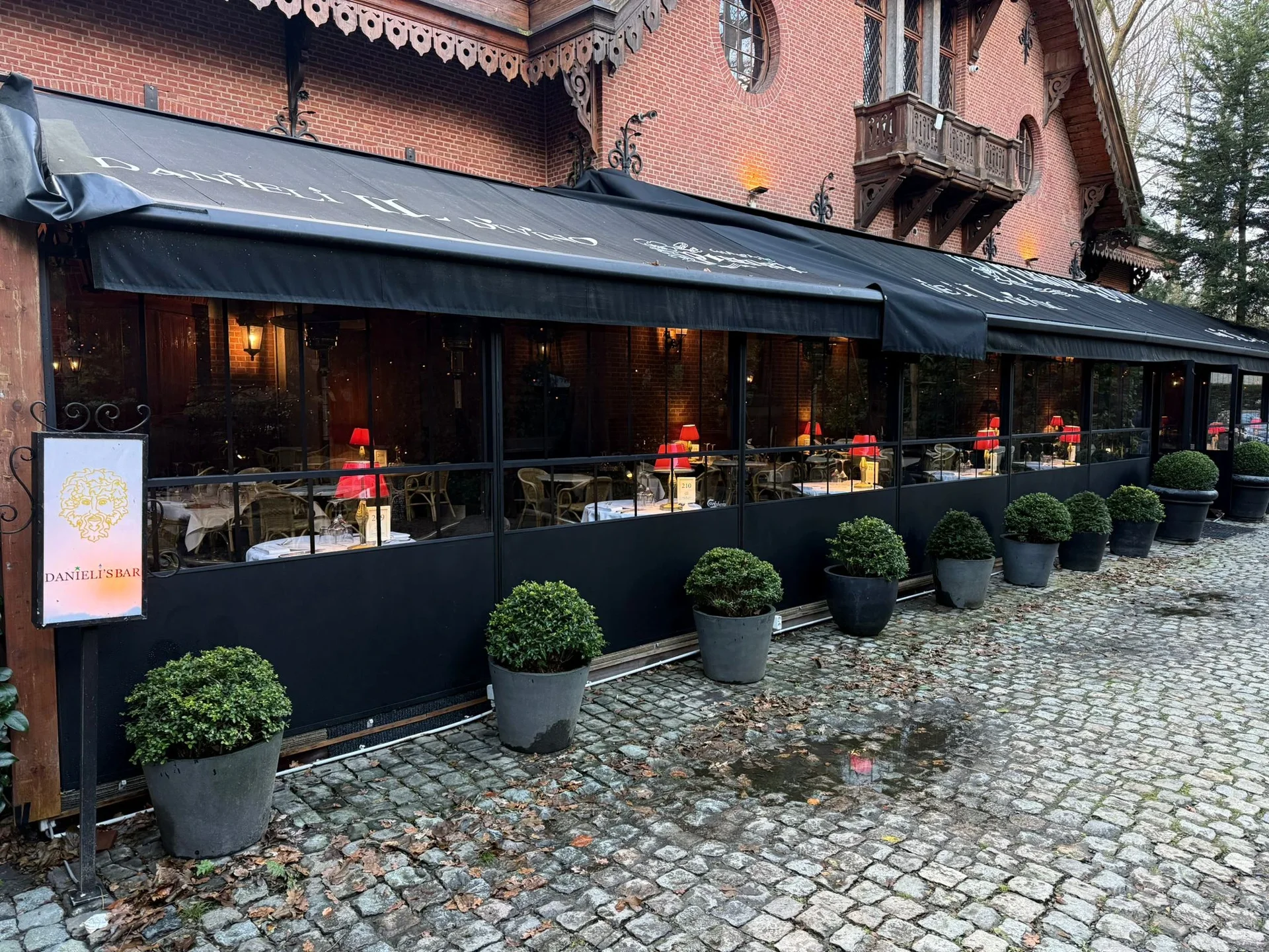 Hydraulischer Glas-Windschutz an einer Restaurantterrasse mit transparenten Glaselementen