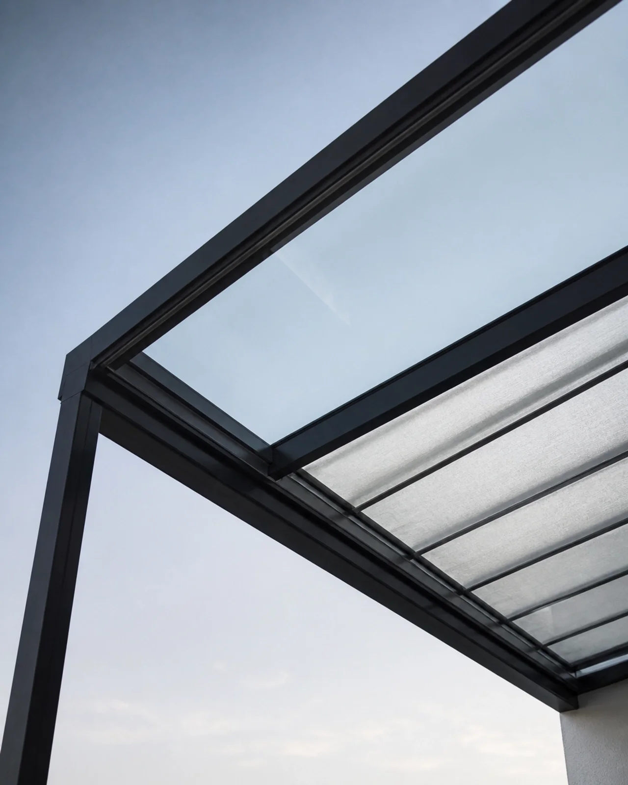 Elegante Terrassenüberdachung aus Glas mit integrierter Markise
