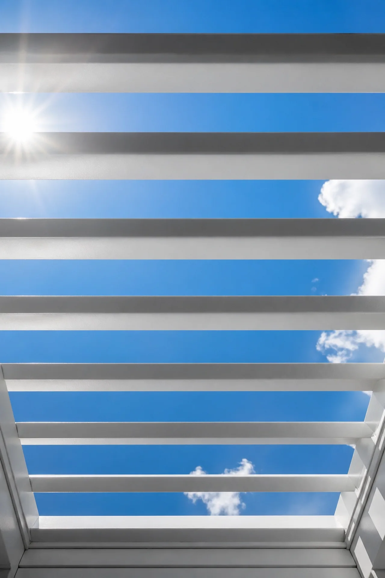 Geöffnete Lamellen eines Lamellendachs bieten perfekten Sonnenschutz und Blick in den Himmel.