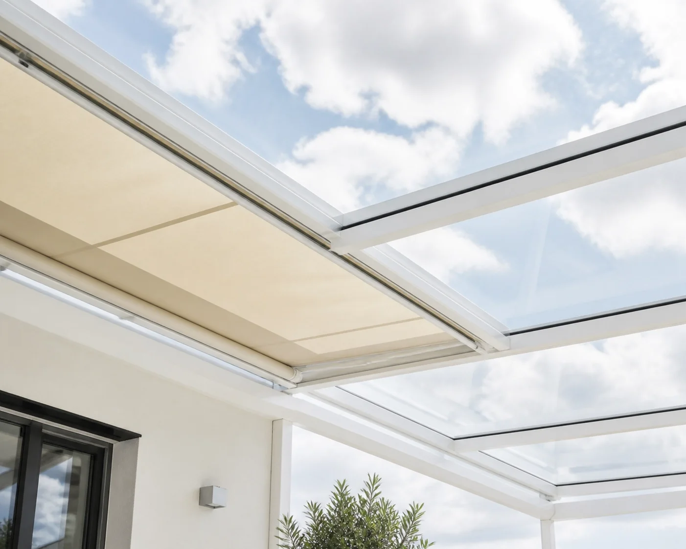 Terrassenüberdachung aus Glas in Wien mit einer hellen Unterglasmarkise als Sonnenschutz.