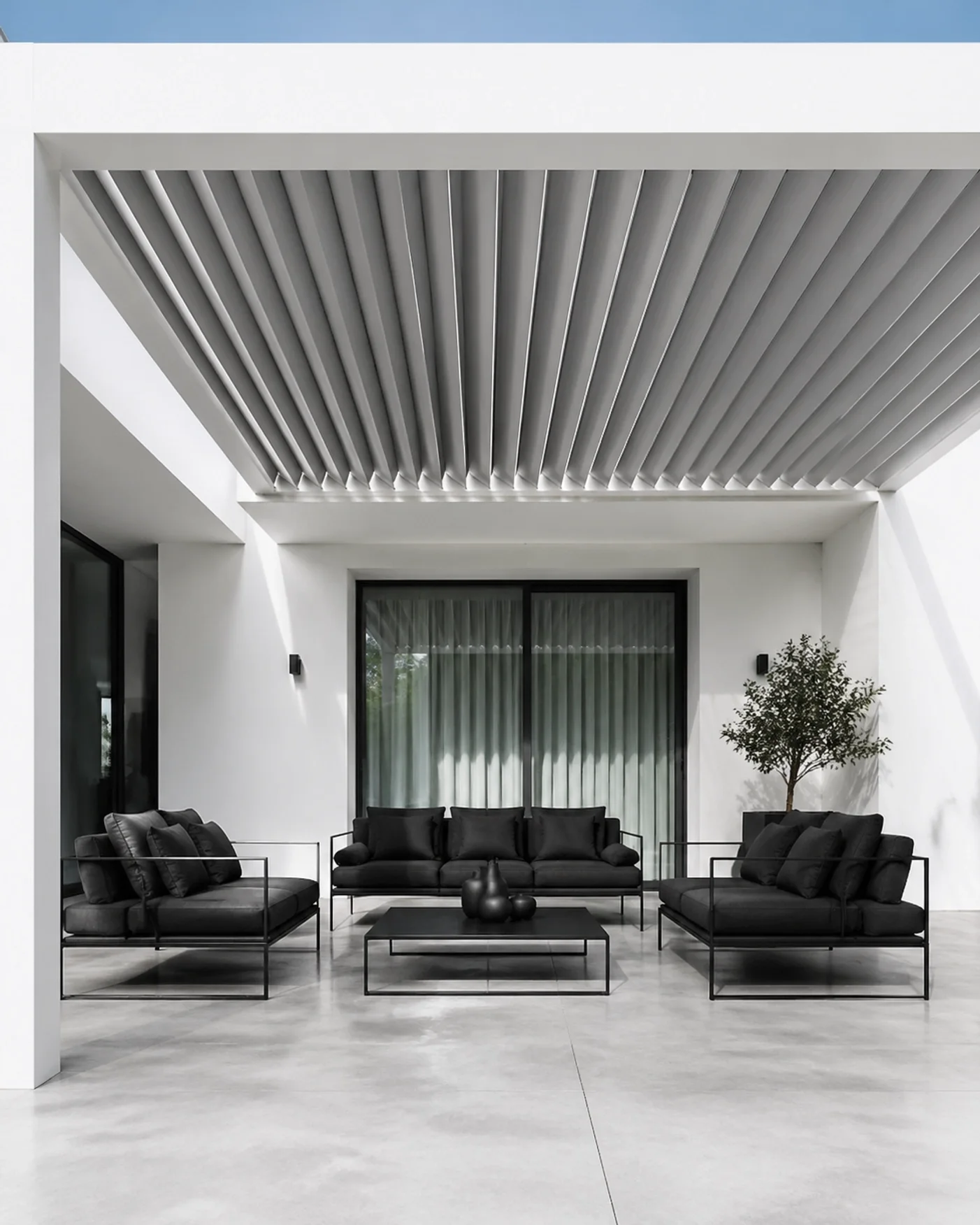 Minimalistische weiße Terrassenüberdachung in Wien mit modernen schwarzen Loungemöbeln.