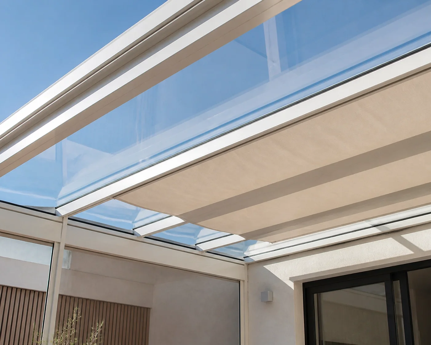 Terrassen-Glasdach mit integrierter Markise als effektiver Hitzeschutz für die Outdoor-Oase.