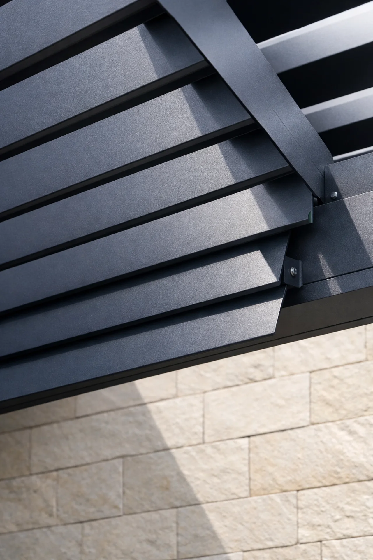 Detail eines anthrazitfarbenen Lamellendachs aus Aluminium für eine moderne Terrassenüberdachung in Wien.