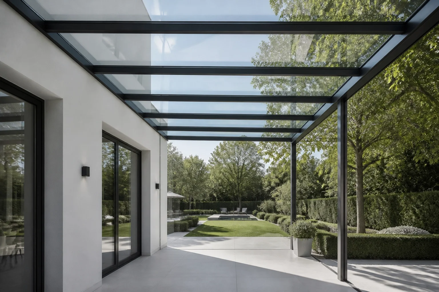 Lichtdurchflutete Terrassenüberdachung Wien: Modernes Glasdach an einer weißen Villa.