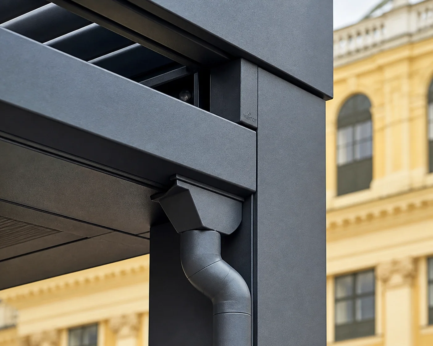 Detail einer wetterfesten Terrassenüberdachung Wien aus Aluminium mit Entwässerungssystem.